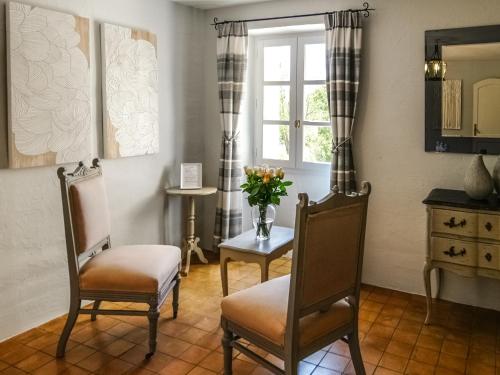 Le BarrouxにあるLa Ferme Des Beluguesのキッチン(椅子2脚、花瓶1本付きのテーブル付)