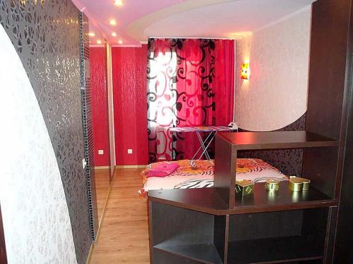ヘルソンにあるNebesnoy Sotni Apartments Centerのベッドと赤いカーテンが備わる部屋