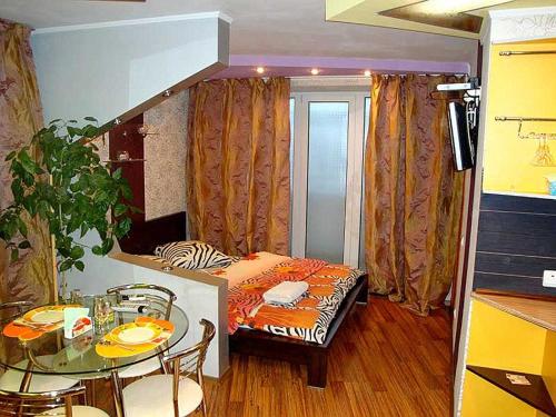ヘルソンにあるTiraspolskaya Apartments Studio Centerのテーブル、ベッド、ダイニングルームが備わる小さな客室です。