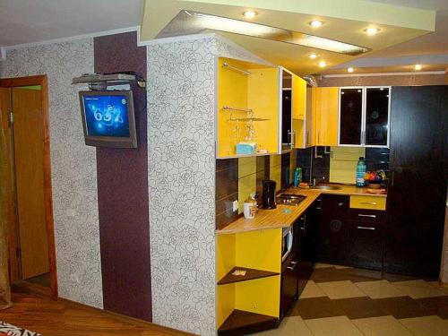 ヘルソンにあるTiraspolskaya Apartments Studio Centerのキッチン(黄色のキャビネット付)、壁掛けテレビ付
