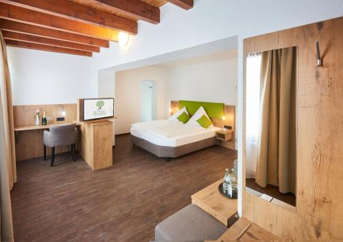 Landhotel Fernblick في Hümmerich: غرفة في الفندق مع سرير ومكتب