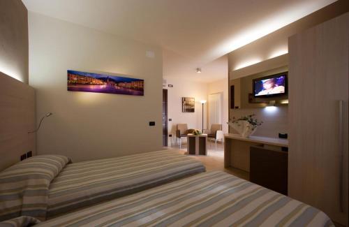 - une chambre avec un lit et une télévision murale dans l'établissement Locanda Benetti, à Costabissara