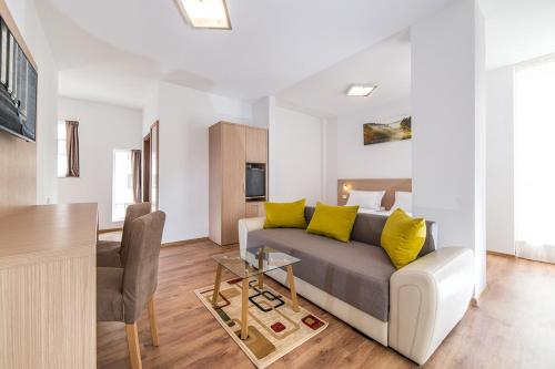 a living room with a couch and a table at Residence iL Lago in Cluj-Napoca