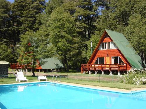 uma casa com uma piscina em frente em Cabañas Pachapulay em Las Trancas