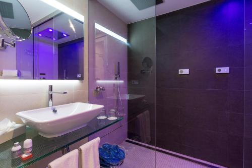 a bathroom with a shower, sink, and mirror at Gran Hotel Reymar in Tossa de Mar