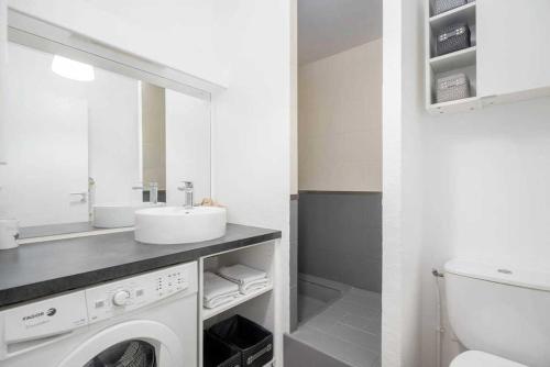 une salle de bain avec un lavabo et une machine à laver dans l'établissement Bayonne et Anglet à pied - Terrasse bois privative, à Anglet