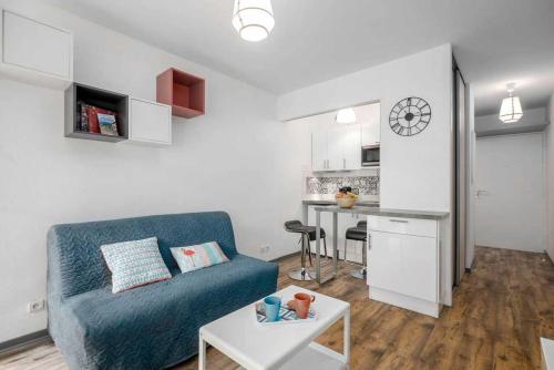 un salon avec un canapé bleu et une table dans l'établissement Bayonne et Anglet à pied - Terrasse bois privative, à Anglet