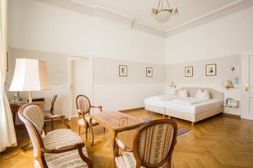 a living room with a bed and a table and chairs at Hotel Schloss Storkau in Storkau