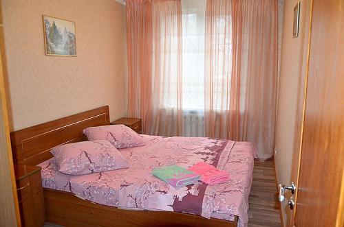 ヘルソンにあるZheleznodorozhnaya Street Apartments Centerのベッドルーム1室(ピンクのシーツが敷かれたベッド1台、窓付)
