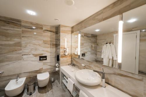 y baño con lavabo, aseo y espejo. en Parklane Resort and SPA, en San Petersburgo