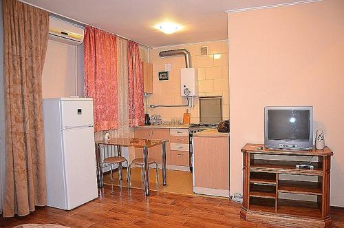 ヘルソンにあるTiraspolskaya Street Apartmentsのキッチン(冷蔵庫、テレビ付きテーブル付)