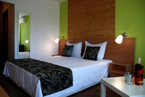 a bedroom with a large white bed with green walls at Green Hisar Hotel Family in Hisarya
