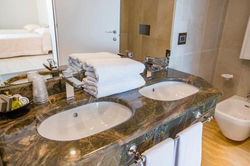 a bathroom with two sinks and a mirror at Victoria Palace Cefalù in Cefalù