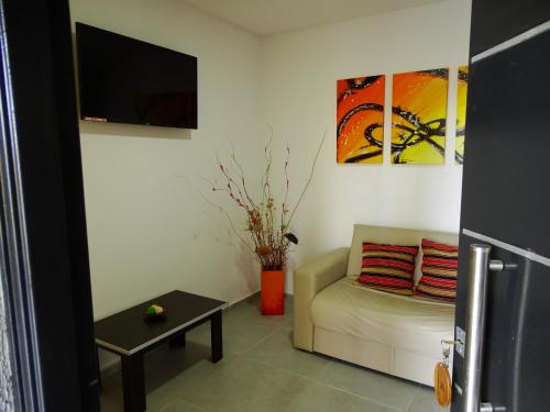 a living room with a couch and a tv at Complejo Turistico Los Troncos in San Rafael