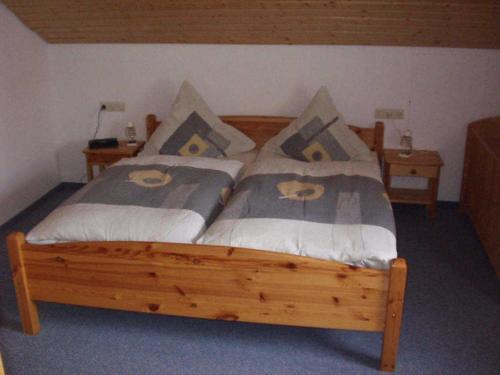 ein Schlafzimmer mit einem Holzbett mit Kissen darauf in der Unterkunft Haus Fechtig in Bonndorf im Schwarzwald