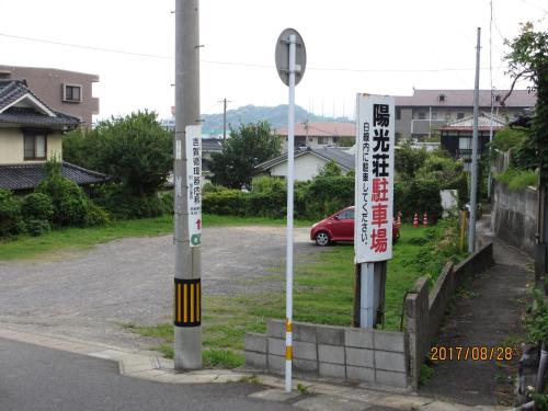 a parking lot with street signs in a city at YOKOSO Ryokan in Beppu