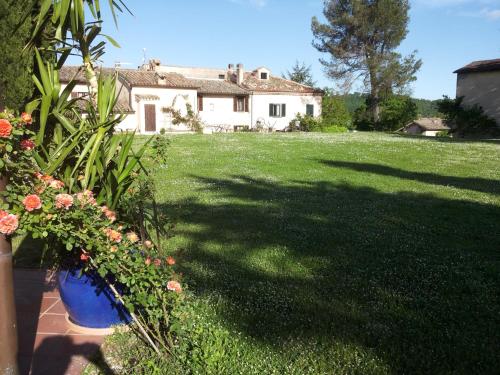 a yard with a house and a large lawn at Ca' le Suore in Cagli