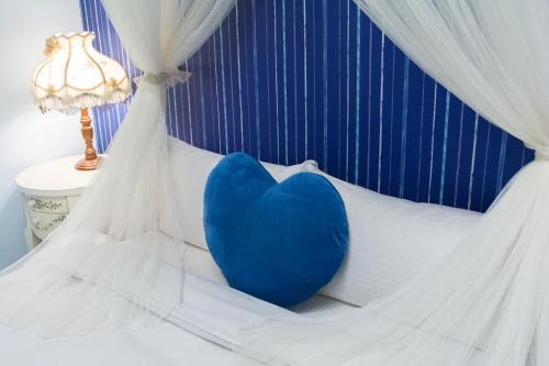 a blue pillow sitting on a bed with a lamp at Elisa House in Jian