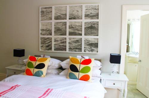 a bedroom with a white bed with colorful pillows at The Laindons in Hastings