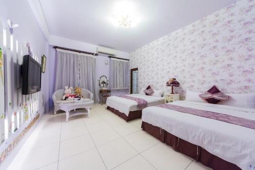 a hotel room with two beds and a tv at Elisa House in Jian