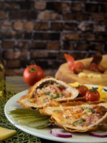 a plate of food with sandwiches and tomatoes on a table at Land-Plan Hotel in Töltéstava