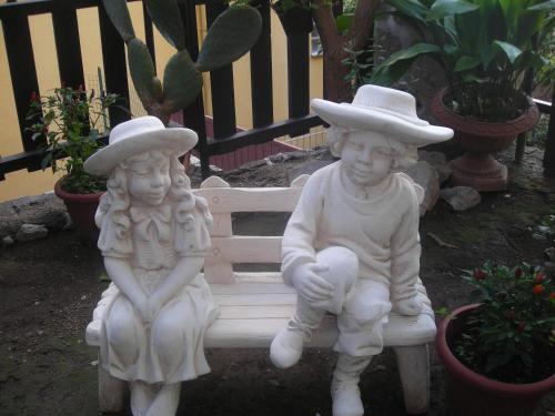 two statues of two children sitting on a bench at B&B L'Arcobaleno in Sorrento