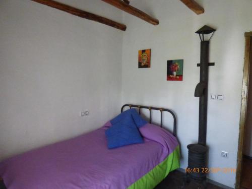 una camera con letto e lenzuola viola di Alojamiento rural El Batán a Priego de Córdoba
