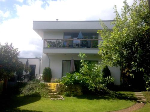 a white house with a balcony and a yard at Pension an der Elsterbrücke in Berlin