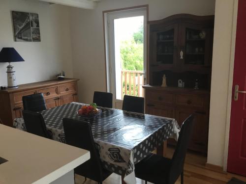 a dining room with a table and chairs and a window at location appartement in Wissant