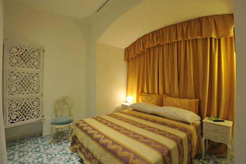 a hotel room with a bed and a chair at Surriento Suites in Sorrento