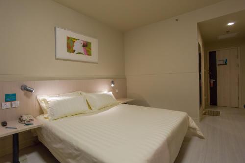 Un dormitorio con una gran cama blanca y una mesa en Jinjiang Inn - Beijing Daxing Development Zone en Daxing