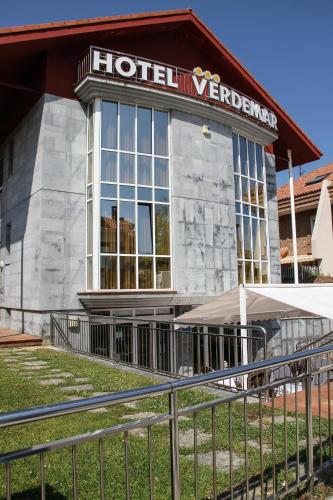 a hotel yard with a fence in front of a building at Hotel Verdemar in Ribadesella