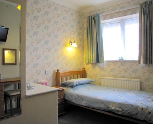 a small bedroom with two beds and a sink at The Loudor in Lincoln