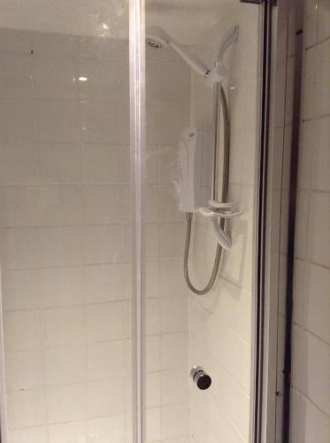 a shower with a shower head in a bathroom at Sea breeze holiday apartment in Weymouth