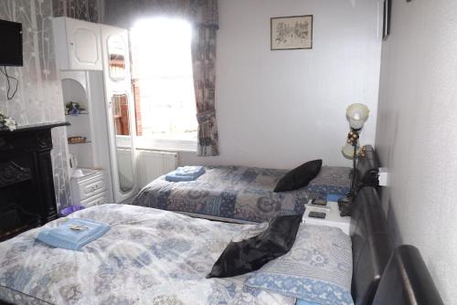 a small room with two beds and a window at Hillcrest Guest House in Llangollen