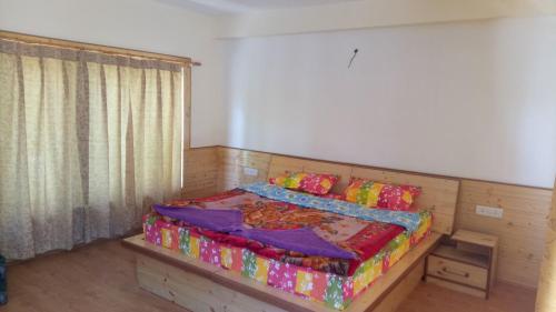 a bedroom with a bed with a wooden frame at Mentokling Guest House and Garden Restaurant in Leh