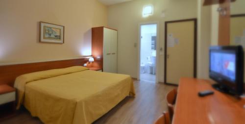 a hotel room with a bed and a flat screen tv at Hotel Genova in La Spezia