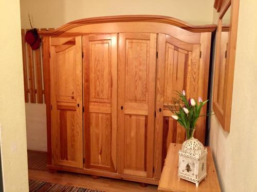 a wooden cabinet with a vase of flowers on a table at Apartment "Gabi" Sonnleitn/Nassfeld in Sonnenalpe Nassfeld