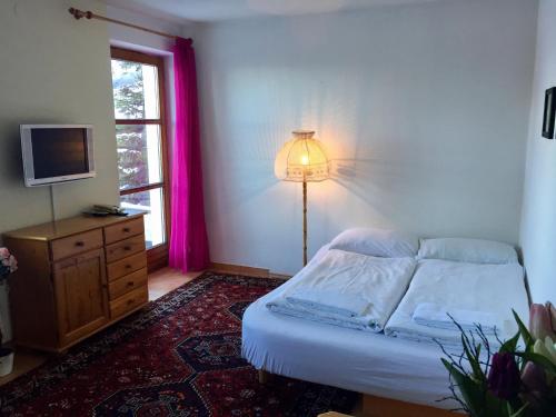 1 dormitorio con cama, lámpara y ventana en Apartment "Gabi" Sonnleitn/Nassfeld, en Sonnenalpe Nassfeld