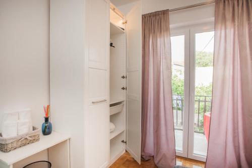 a room with a sliding glass door with a balcony at Hostel Splendido in Šibenik