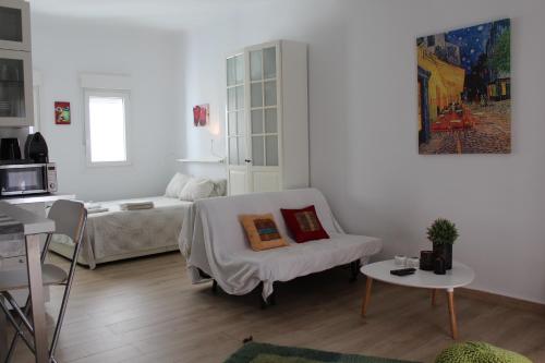 Sala de estar blanca con cama y sofá en Ronda de Segovia, en Madrid