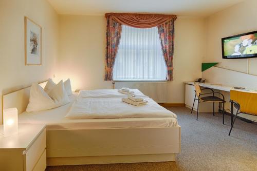 格拉的住宿－加爾艮堡酒店，酒店客房配有一张床、一张书桌和一台电视。