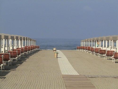 a row of beach chairs on a pier with the ocean at Stabilimento balneare Bragozzo in Lido di Camaiore