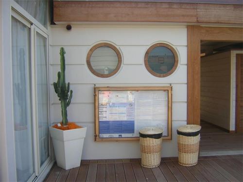 a building with three windows and a cactus on a porch at Stabilimento balneare Bragozzo in Lido di Camaiore