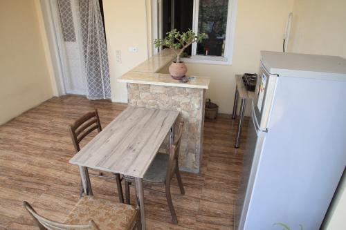 una cucina con tavolo in legno e frigorifero di Guest house Ebralidze a Mtskheta