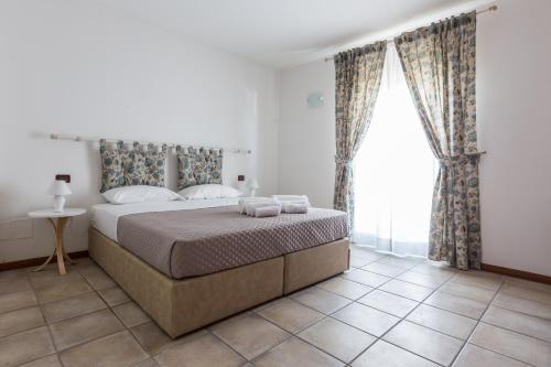 a bedroom with a bed and a large window at Le Campane di Assisi in Assisi