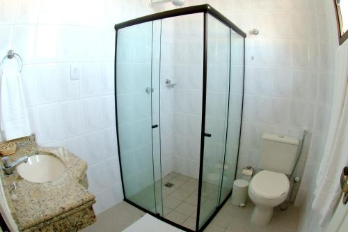 a bathroom with a glass shower and a toilet at San Manuel Praia Hotel in Aracaju