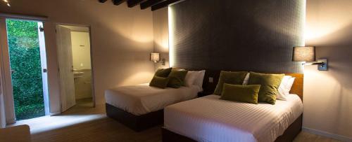 a hotel room with two beds and a window at Othelo Boutique Hotel Mexico in León