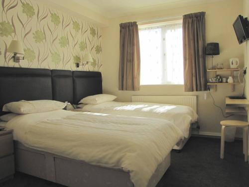 a bedroom with two beds and a window at The Loudor in Lincoln