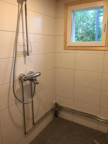 y baño con ducha y ventana. en Mäntyharju-mökki, en Syöte